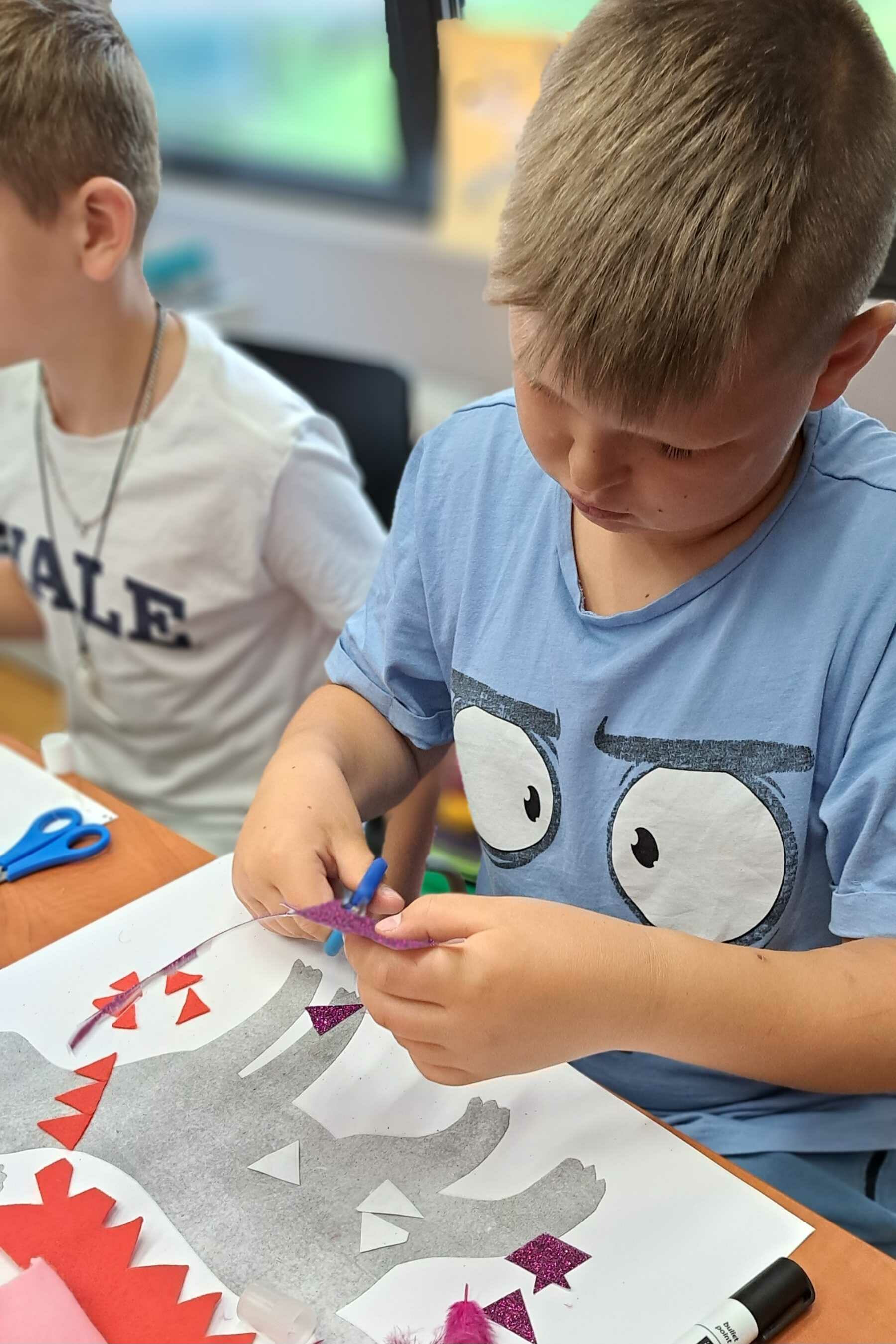 chłopiec wykonuje pracę plastyczną