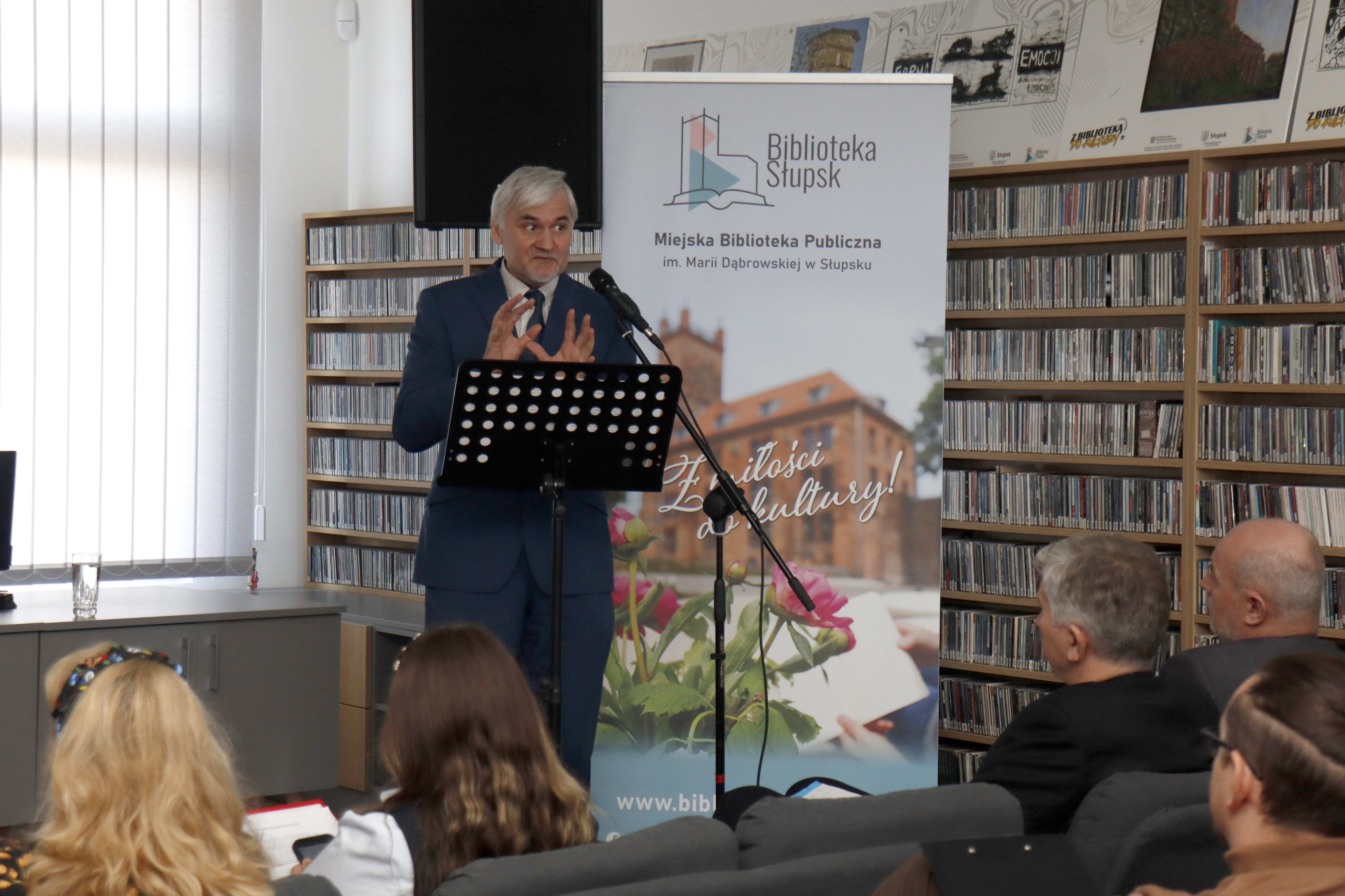 głowy publiczności na pierwszym tle, w oddali w centralnej części zdjęcia przemawiający referent