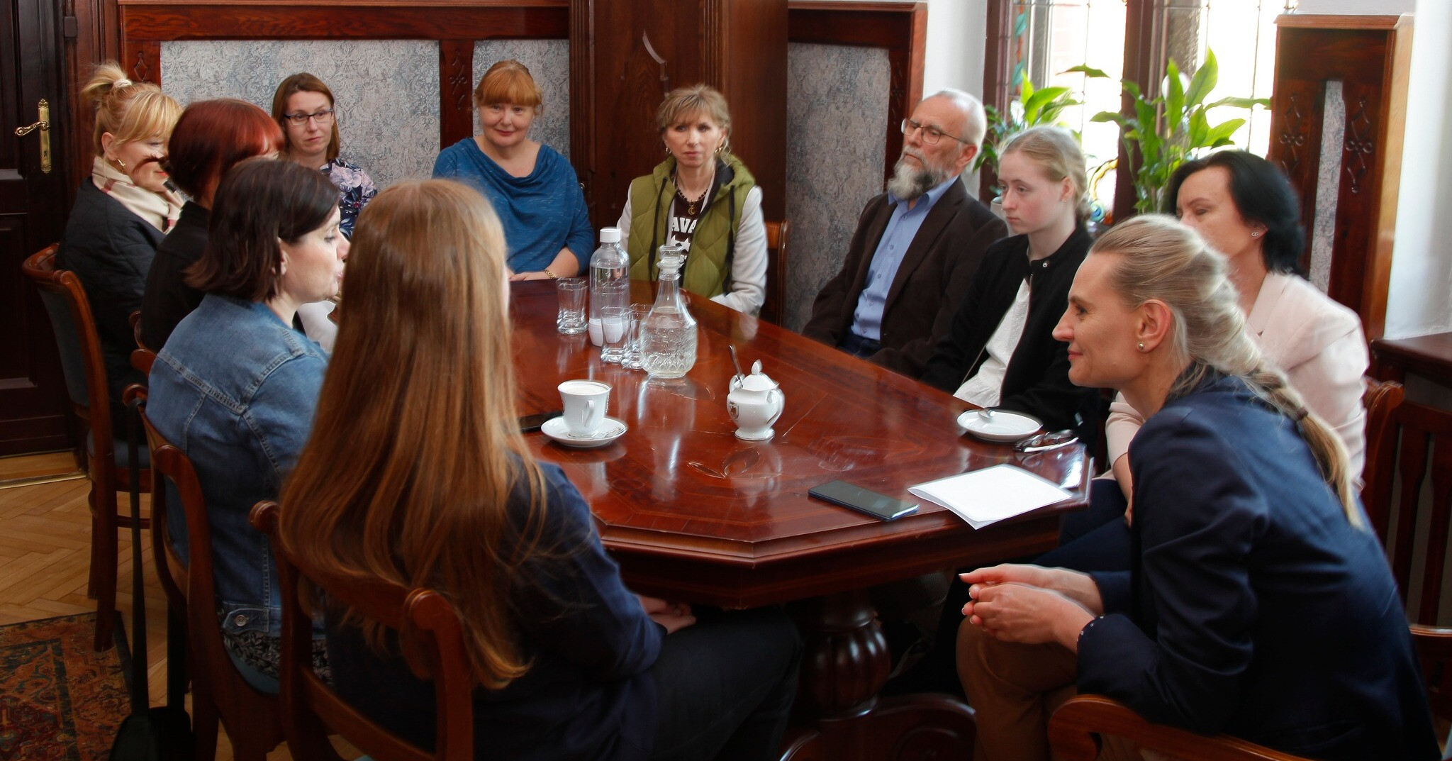 przy stole siedzi 11-sioro ludzi, uśmiechają się