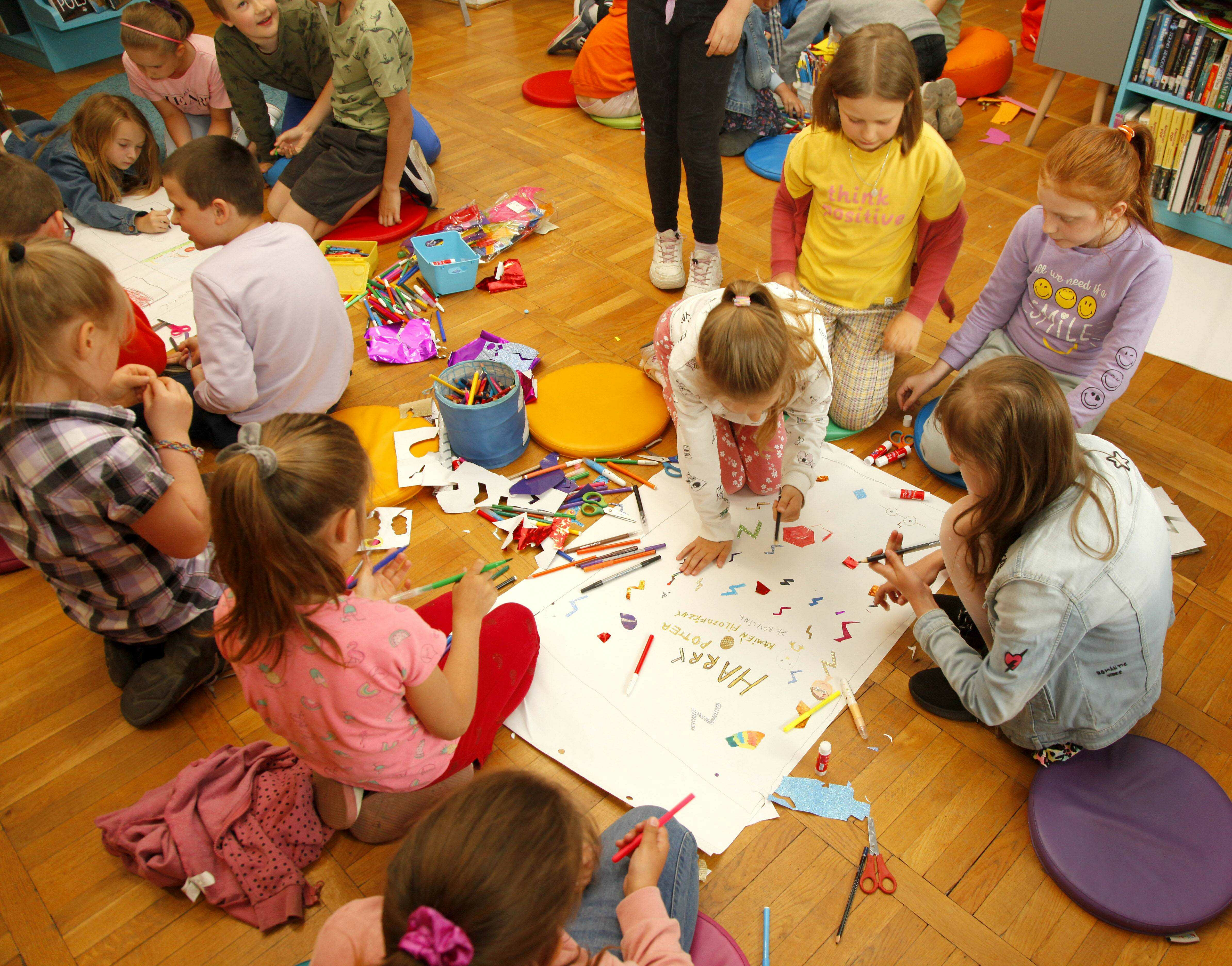 dzieci w grupach tworzą prace plastyczne