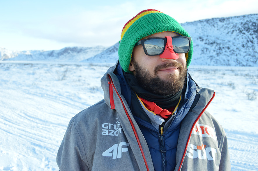 uśmiechnięty mężczyzna w okularach przeciwsłonecznych na tle zaśnieżonego krajobrazu